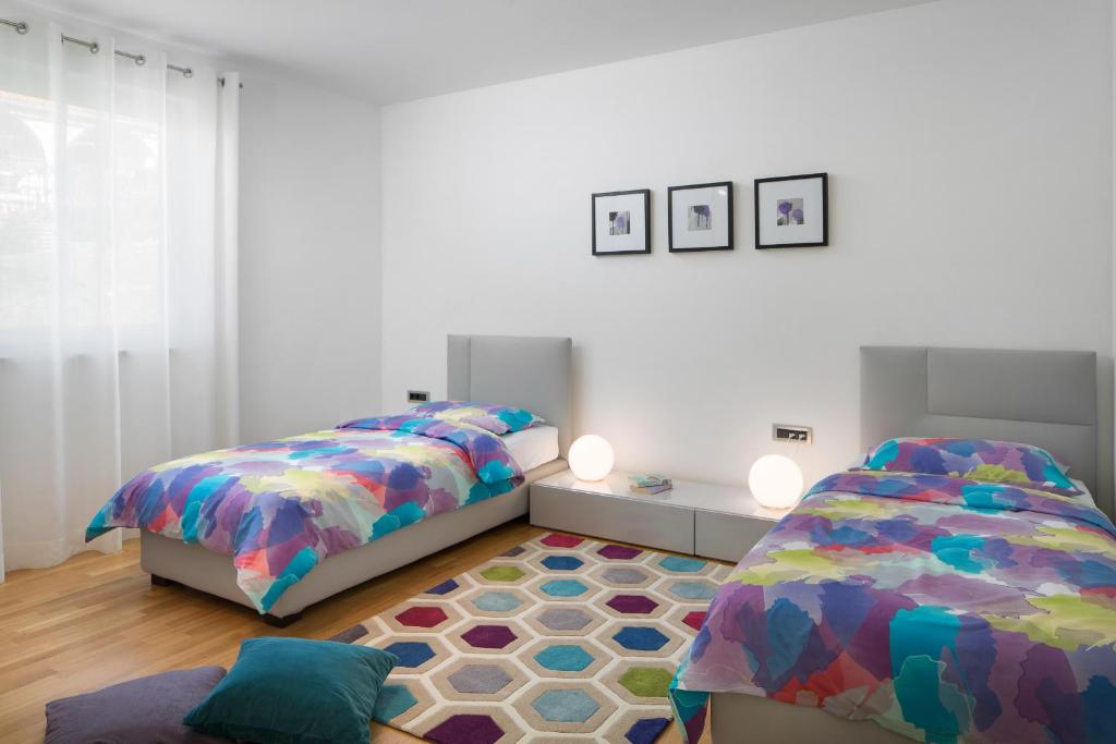 sypialnia z 2 łóżkami i dywanem w obiekcie Villa L - Villa with 2 separate units w mieście Labin