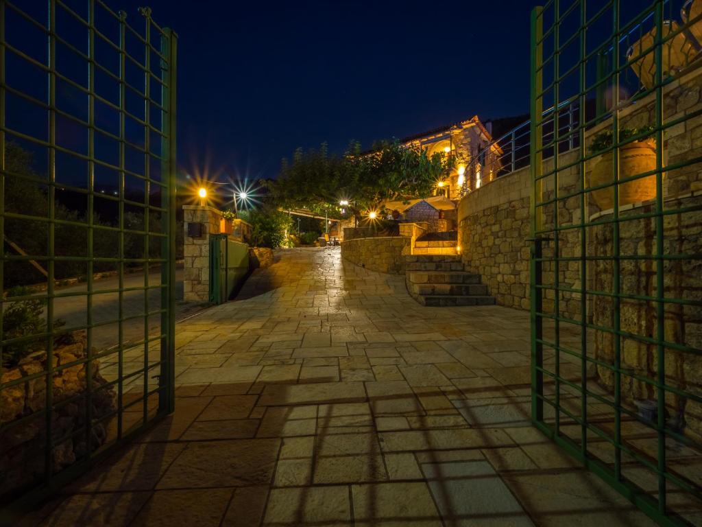 an empty street at night with a fence at Palataki in Kardamyli