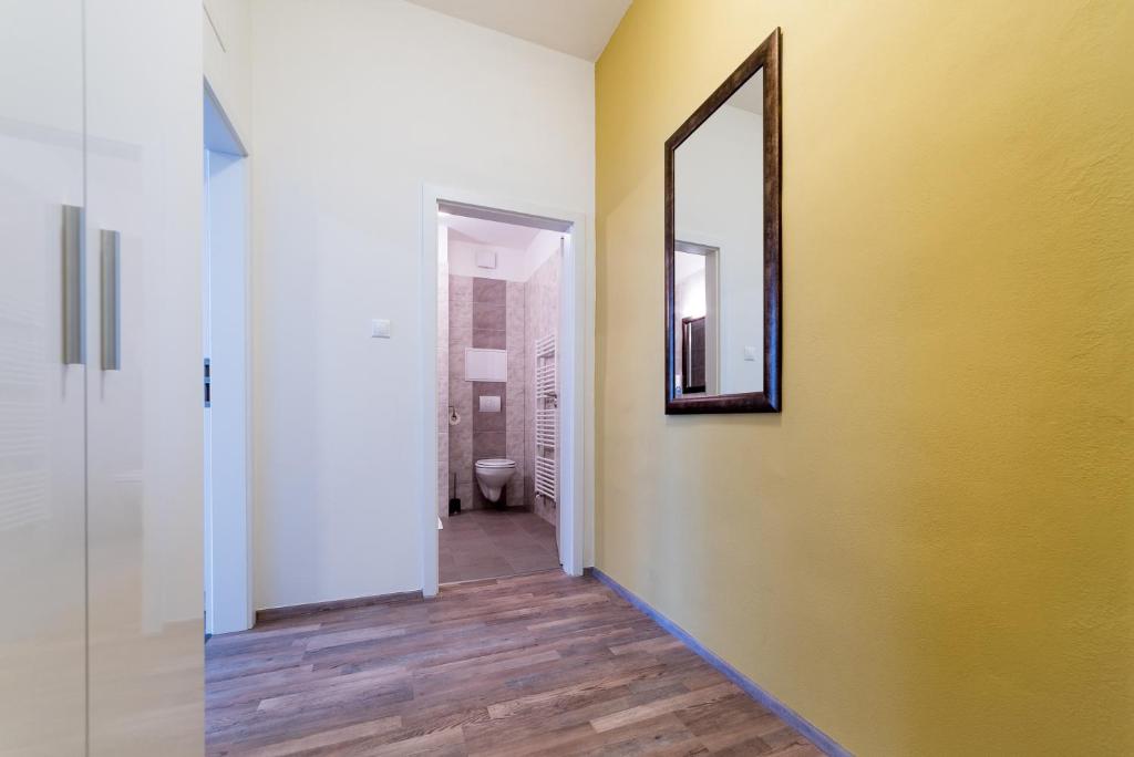 korytarz z lustrem i żółtą ścianą w obiekcie MyApartment in the city center w Czeskich Budziejowicach