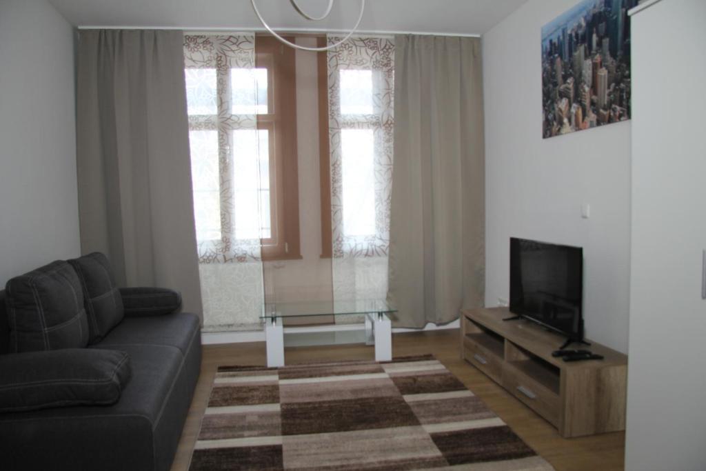 a living room with a couch and a flat screen tv at Apartment Nürnberg City in Nuremberg