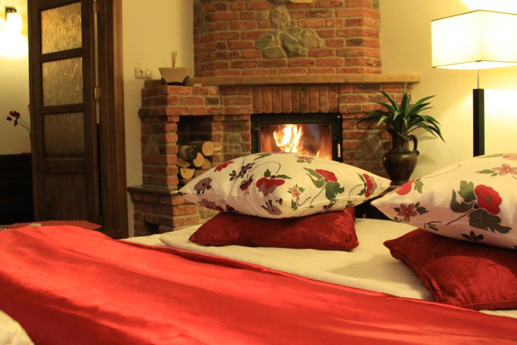 a bed with pillows and a fireplace in a room at Hotel Polak in Zamość