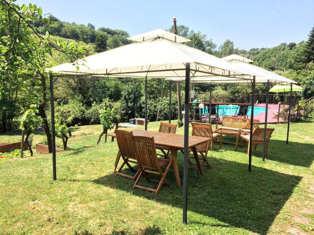 un tavolo e sedie sotto un ombrellone nell'erba di Casa Al Chianti B&B a Greve in Chianti