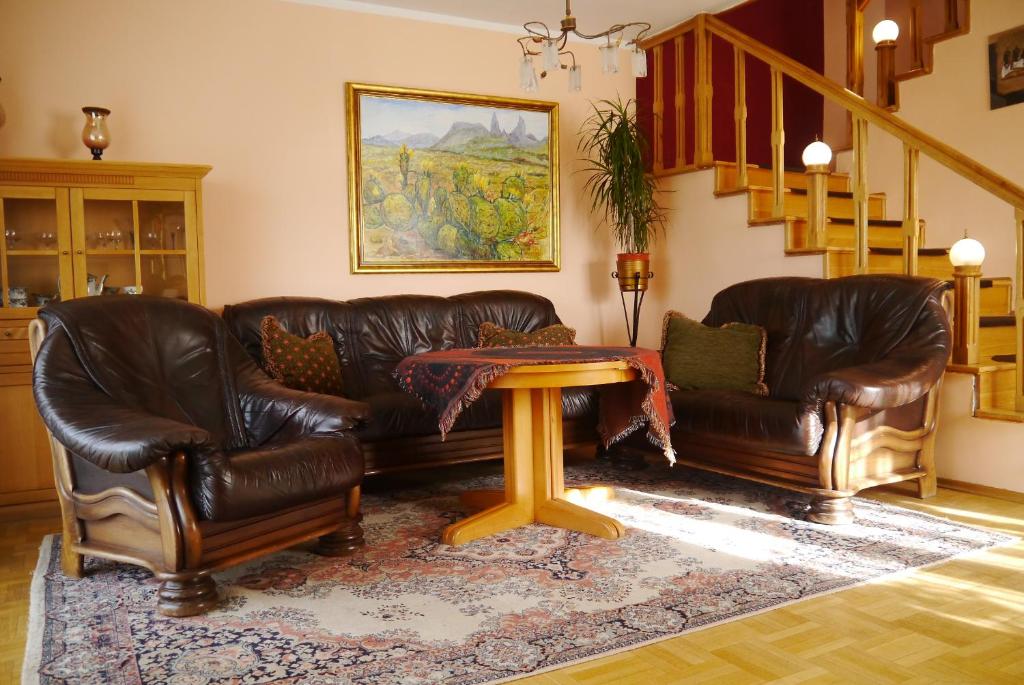 a living room with two leather couches and a table at Willa Łebska in Gdynia