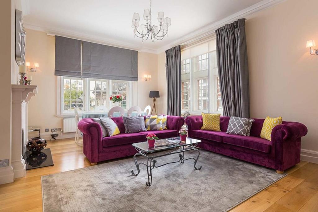 a living room with purple couches and a table at Apartment on Duke Street in London