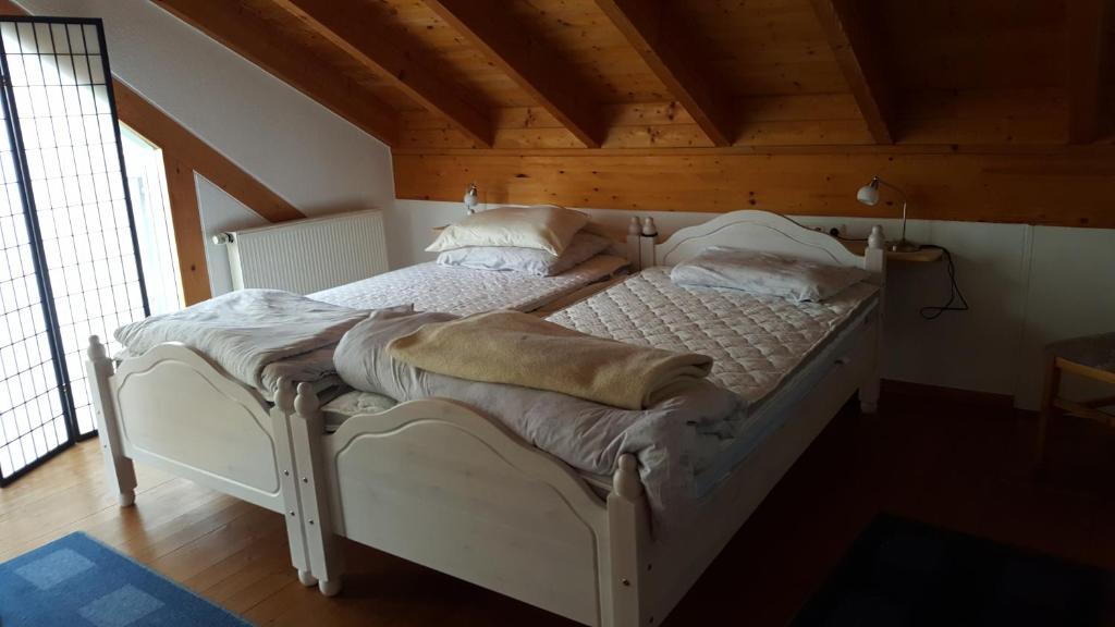 ケルンにあるBB dänisch/deutschの木製天井の客室の白いベッド1台分です。