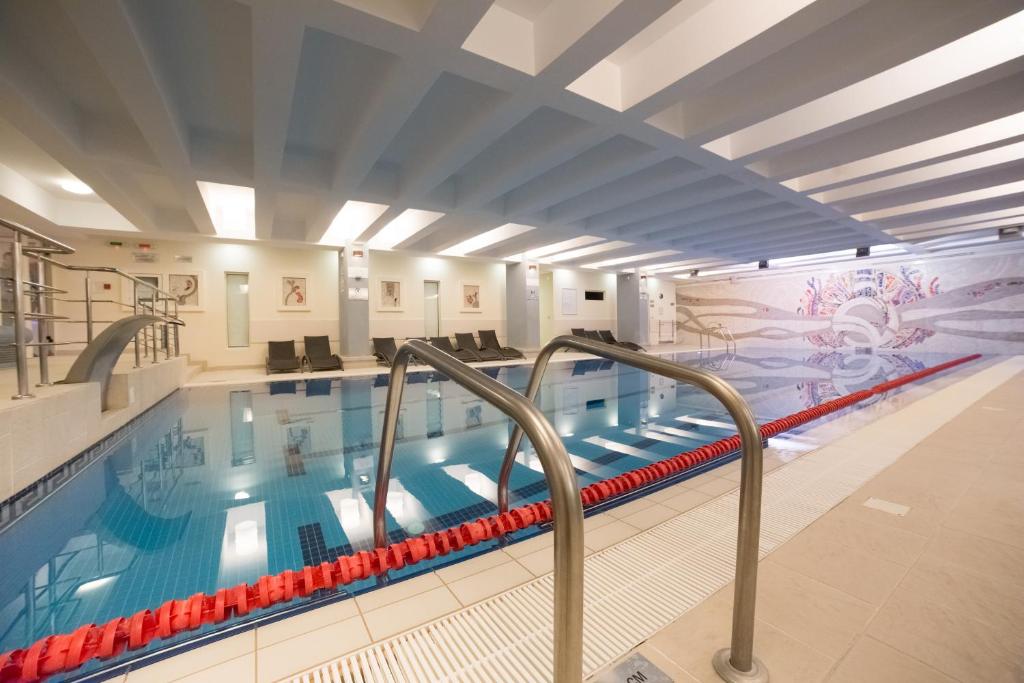 a large swimming pool with a mural on the wall at Unirea Hotel & Spa in Iaşi