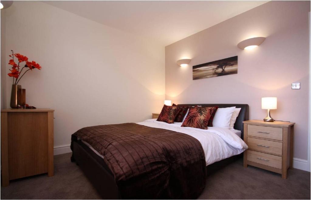 a bedroom with a large bed and two night stands at Montague House in Wokingham