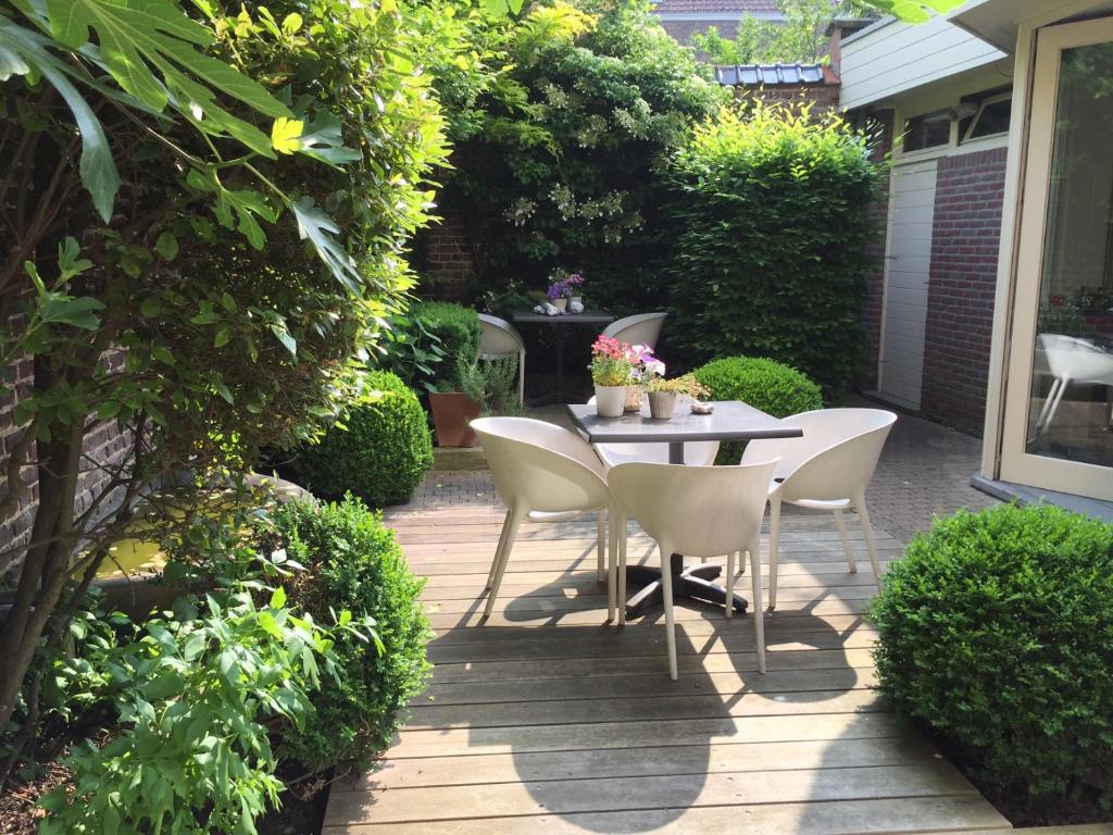 a patio with a table and chairs in a garden at B&B Sabbajon in Ypres