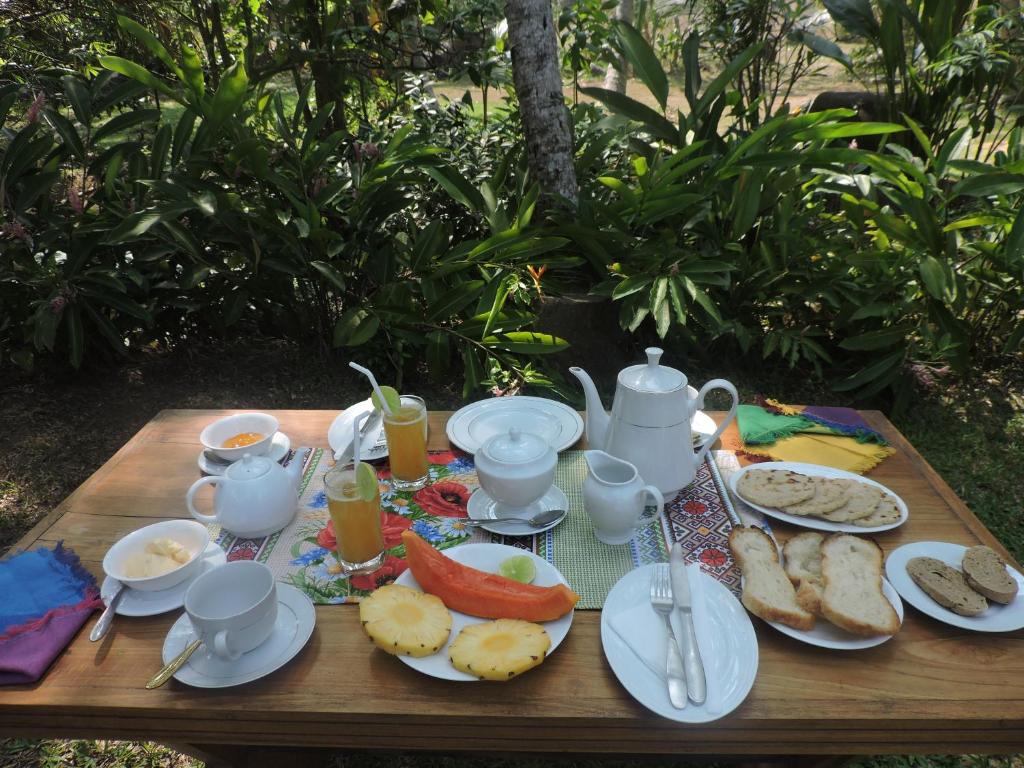 a wooden table with breakfast foods and drinks on it at Silva Rest in Unawatuna