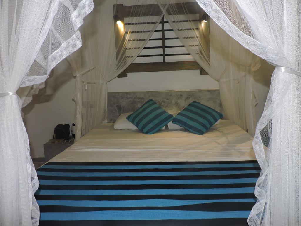 a bed with blue and white pillows in a bedroom at Silva Rest in Unawatuna