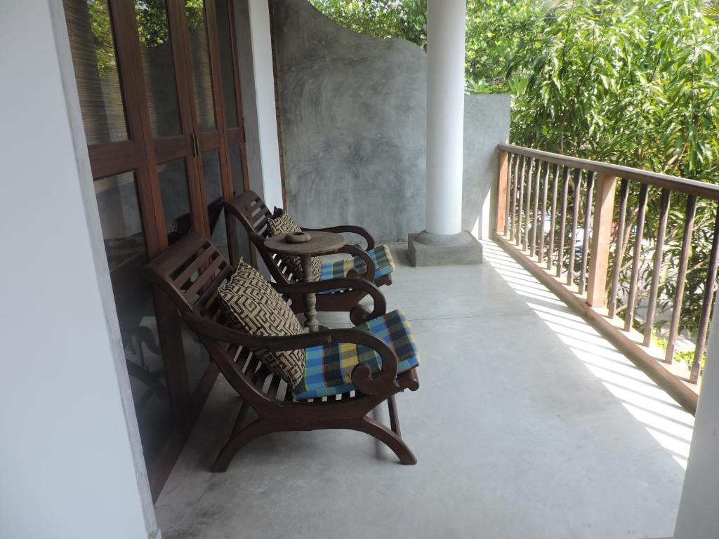 a porch with two chairs and a table on a balcony at Silva Rest in Unawatuna