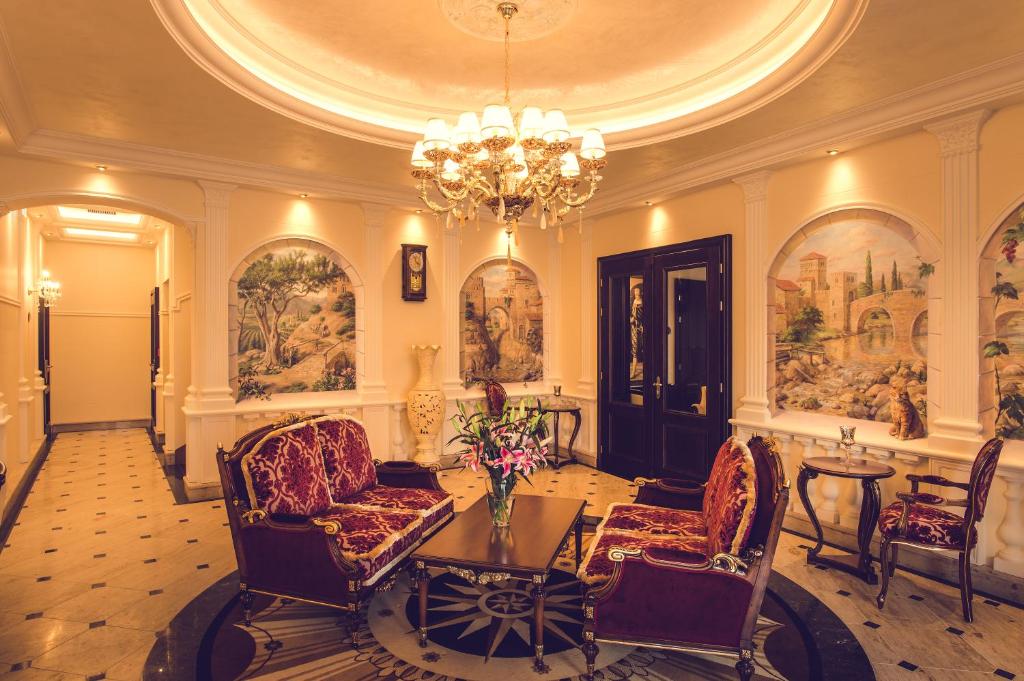 a lobby with a chandelier and chairs and a table at Hotel Florian Palace in Jindrichuv Hradec
