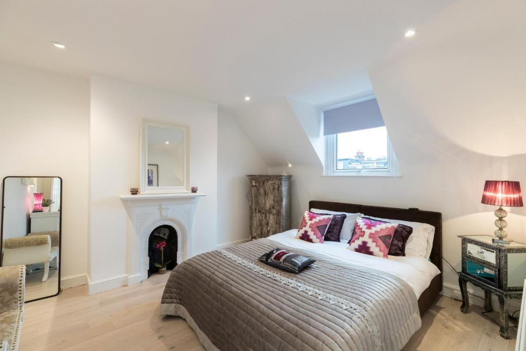 a bedroom with a bed and a fireplace at ALTIDO Pleasant 2-bed flat near River Thames in London