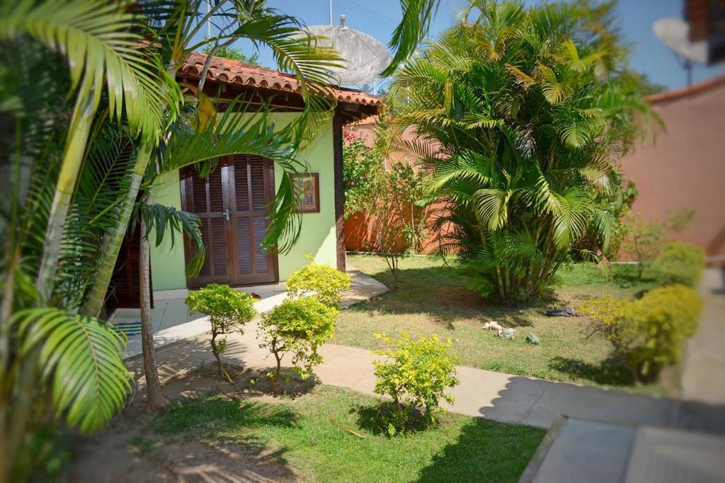 una pequeña casa con palmeras delante en Geribá Homestay, en Búzios