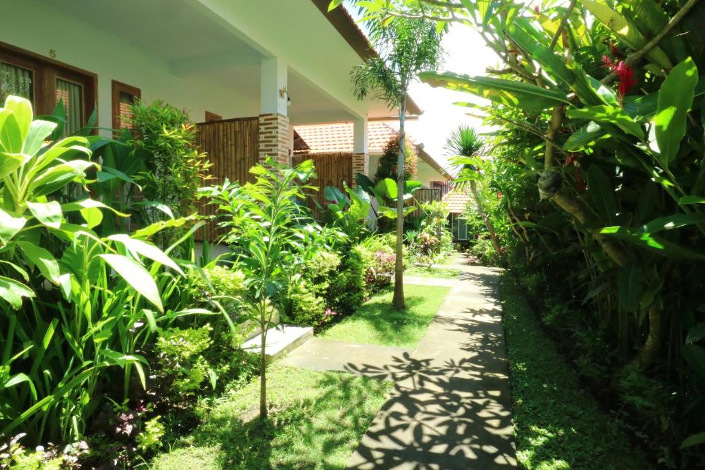 a garden path leading to a house at The Wina Guest House 2 in Canggu