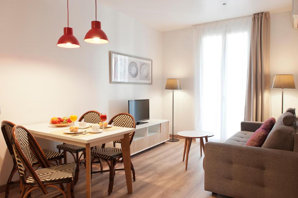 MH Apartments S. Familia في برشلونة: غرفة معيشة مع طاولة وكراسي وأريكة