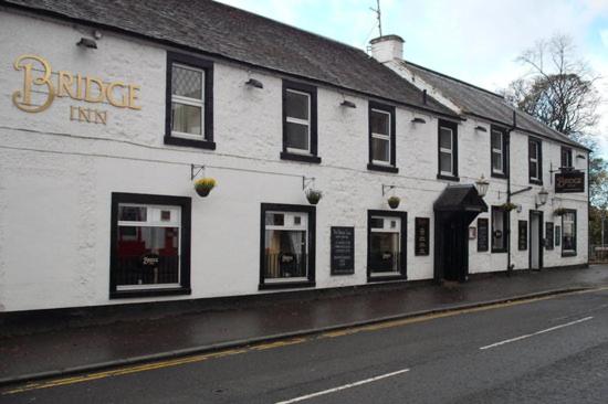 un edificio blanco al lado de una calle en The Bridge Inn en Tillicoultry