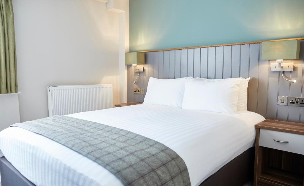 uma grande cama branca num quarto de hotel em Fishermans Tavern em Dundee