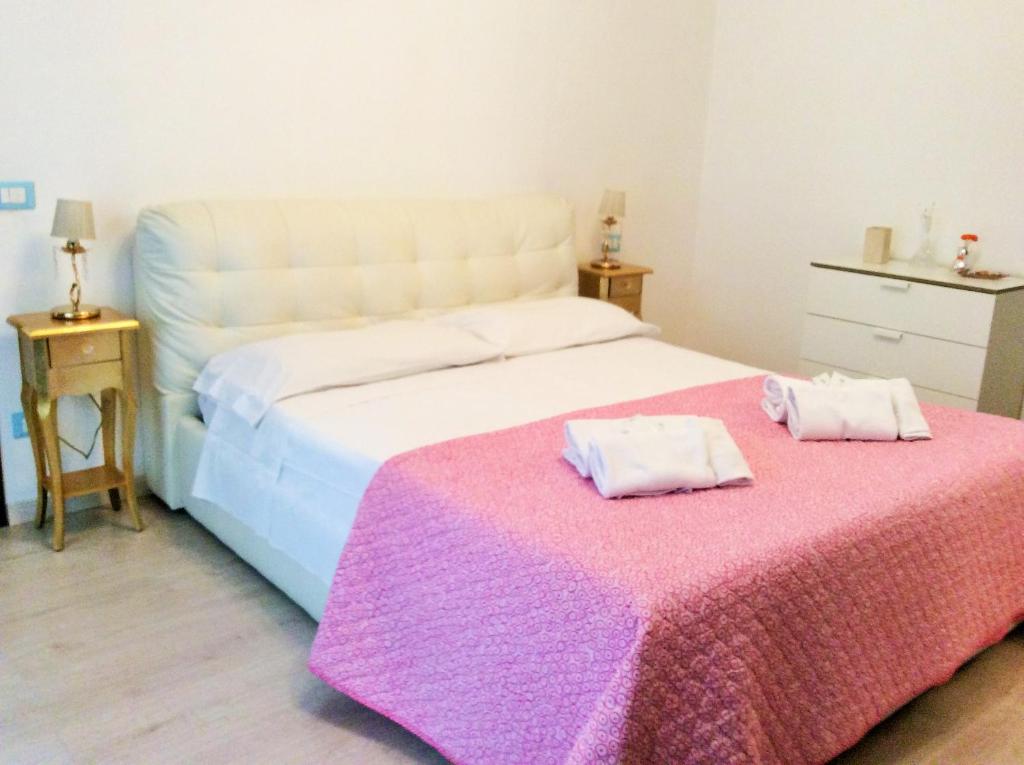 una camera da letto con un grande letto con una coperta rosa di Marconi Flat a Roma