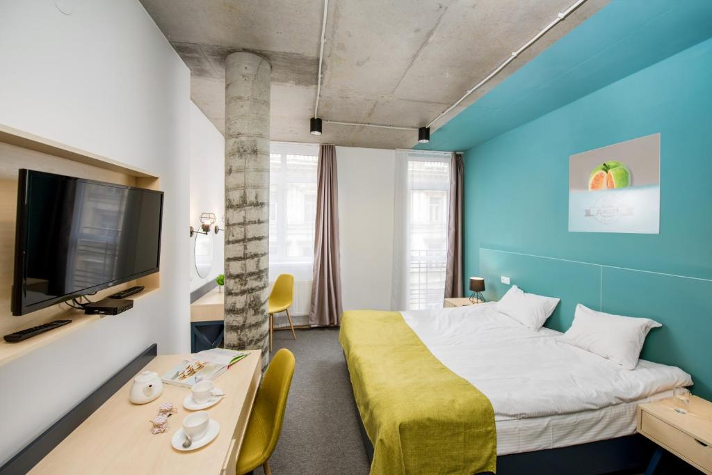Jam Hotel Hnatyuka في إلفيف: غرفة الفندق بسرير وطاولة