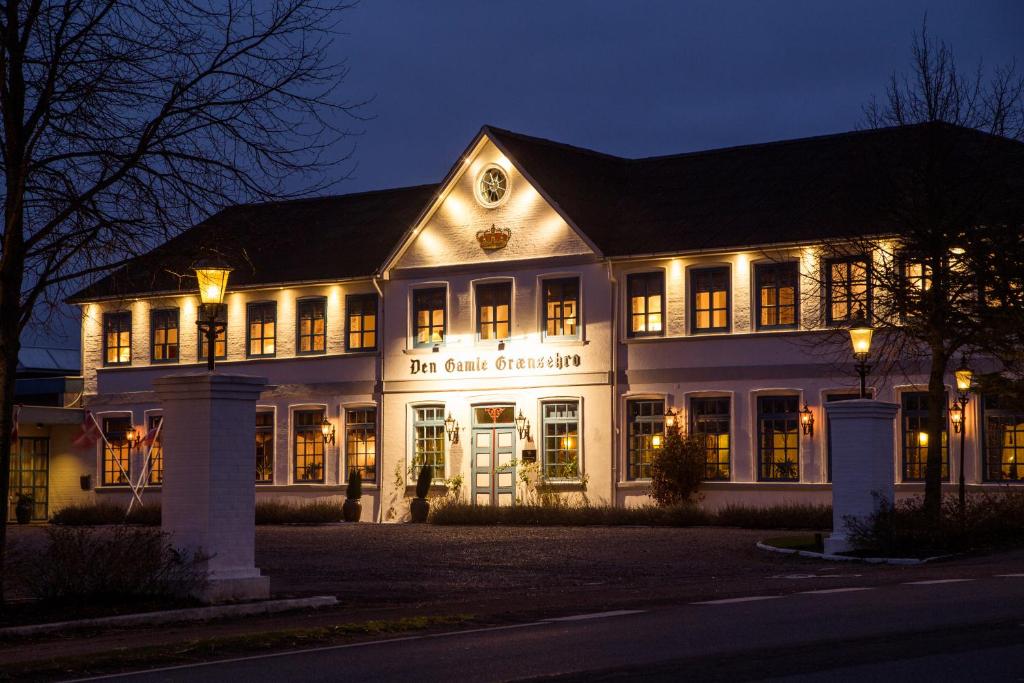 Den Gamle Grænsekro Inn في كريستانسفيلد: مبنى مضاء في الليل مع انارة