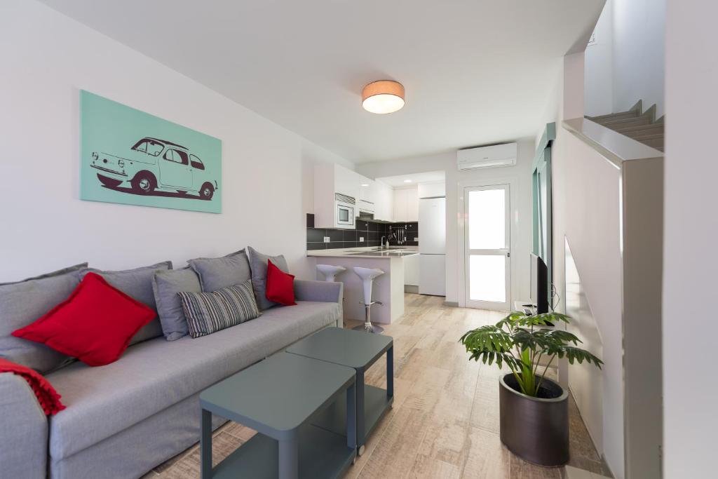 un salon avec un canapé gris et une table dans l'établissement Bungalow tipo duplex en Sonneland, Maspalomas, à Maspalomas
