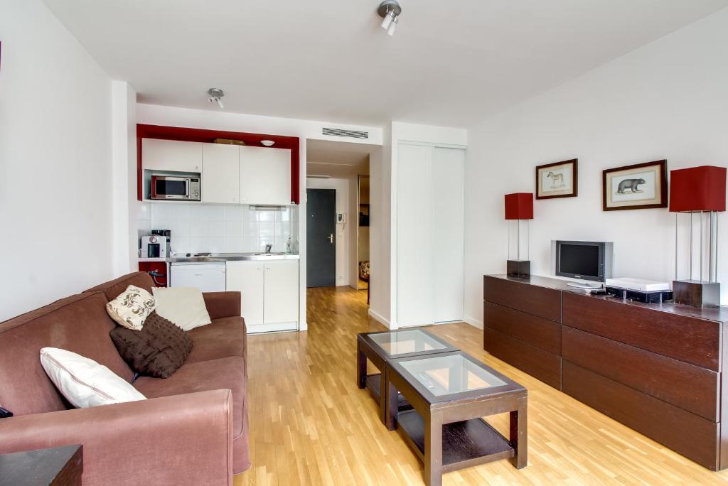 un salon avec un canapé et une table dans l'établissement Champs Elysées George V ID 306, à Paris