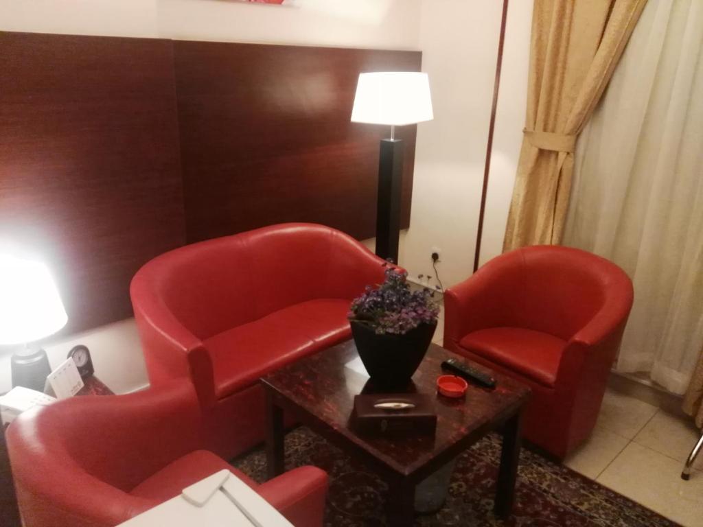 a living room with two red chairs and a table at Al Aseel Ajyad in Mecca