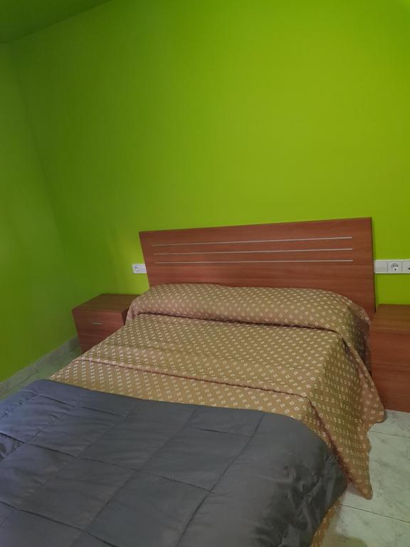 um quarto com uma cama de madeira e uma parede verde em Hostal Europa em Tarragona