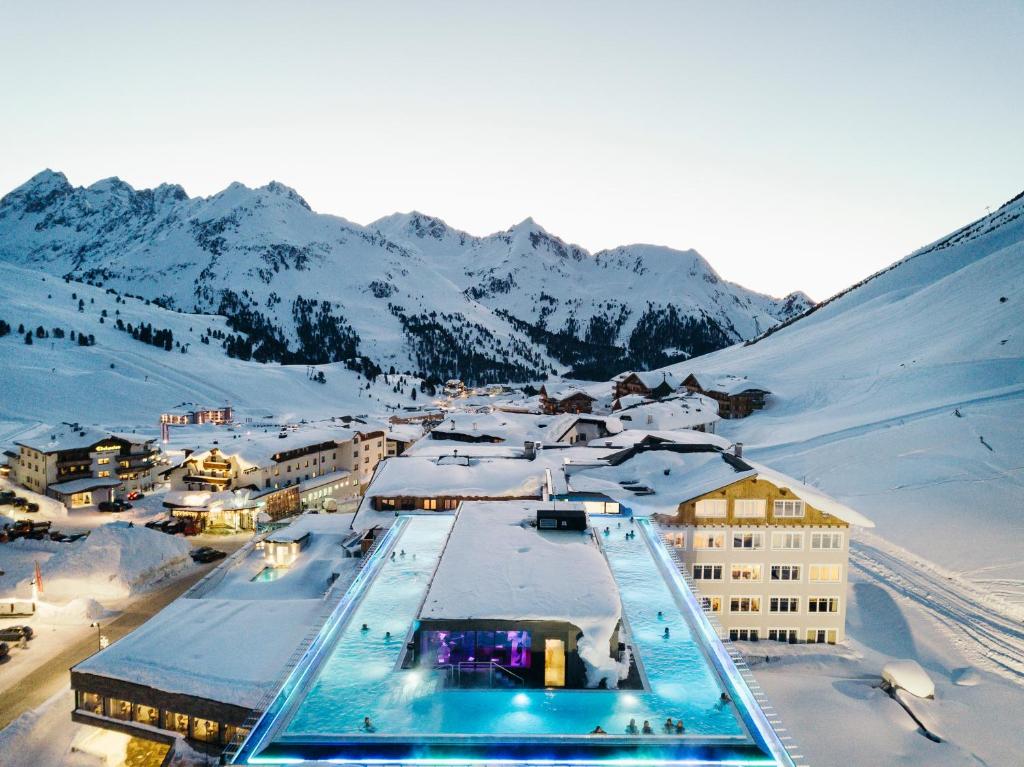 a resort with a swimming pool in the snow at Mooshaus Winterresort in Kühtai