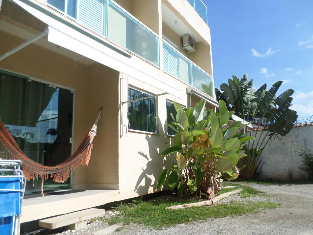 ein Haus mit einer Hängematte draußen in der Unterkunft Residencial Camburyá in Camburi