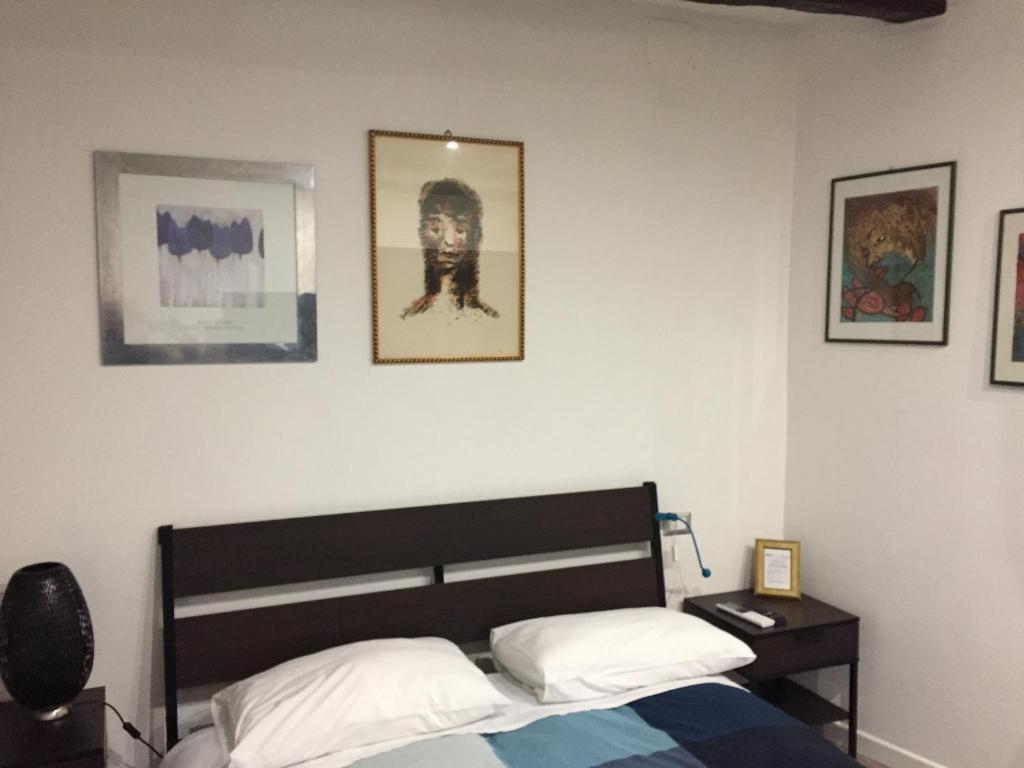 sypialnia z łóżkiem i obrazami na ścianie w obiekcie Waterfall Vicolo V w mieście Isola del Liri