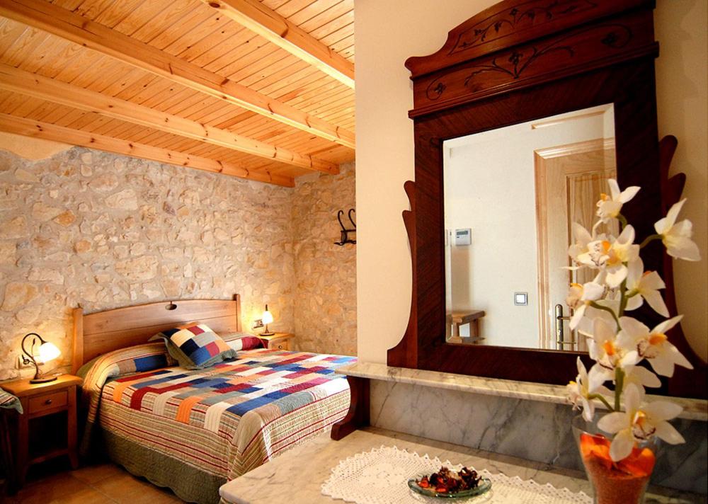 a bedroom with a bed and a large mirror at Ca l'Americano in Llacuna