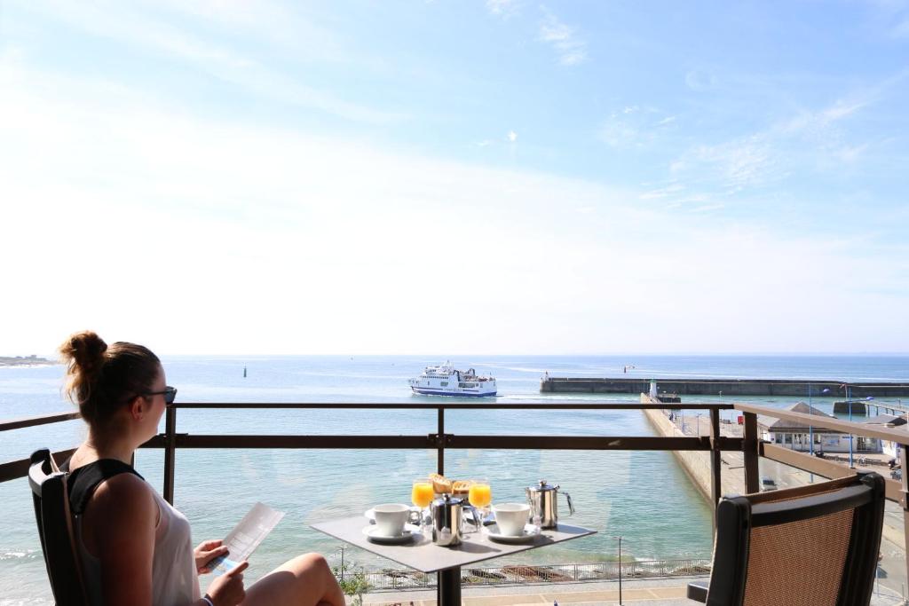 een vrouw aan een tafel die uitkijkt op de oceaan bij Albatros in Quiberon