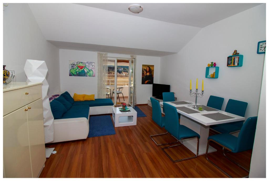 a living room with a table and blue chairs at Apartment Mona Lisa in Mokošica