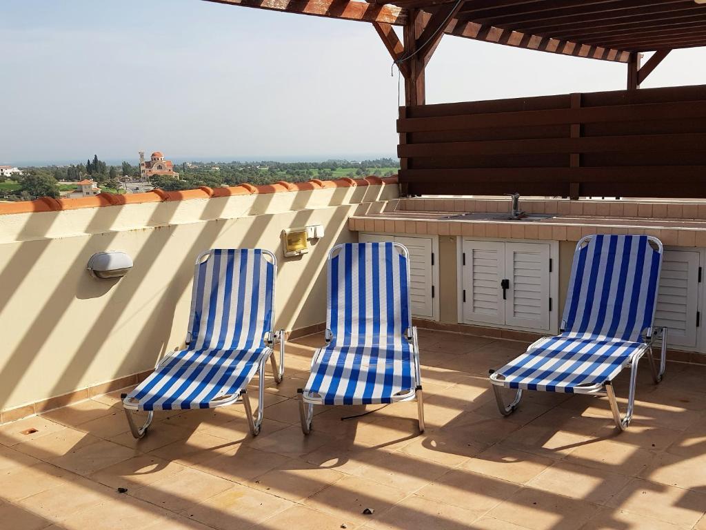 a pair of blue chairs sitting on top of a roof at Mazotos Panoramic Village in Mazotos