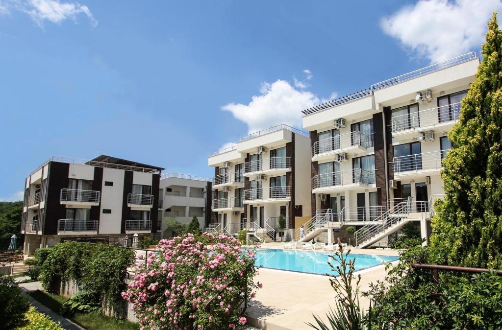 kompleks apartamentów z basenem i kwiatami w obiekcie Seaside Apartment NLV w Słonecznym Brzegu