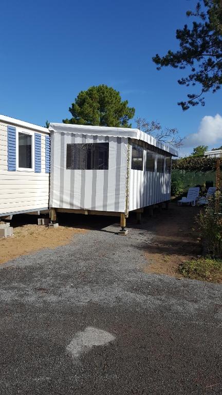 Um par de autocaravanas estacionadas num parque de estacionamento. em Le Bois Dormant em Saint-Jean-de-Monts