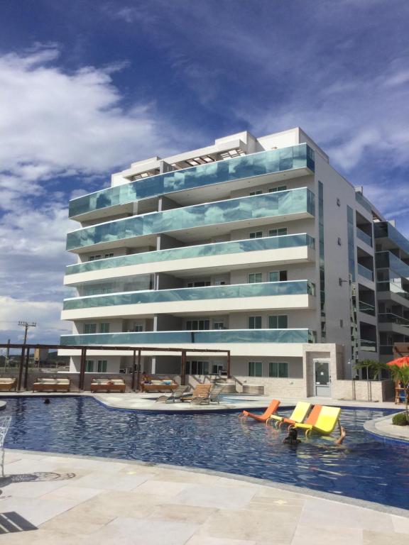 un gran edificio con una piscina frente a él en Apto no Le Bon Vivant Praia Grande, en Arraial do Cabo