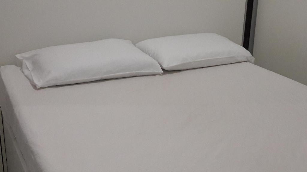 dwie białe poduszki siedzące na łóżku w obiekcie Park Studio w mieście Brasília
