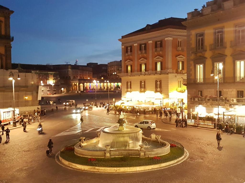 a large fountain in the middle of a city at night at B&B Dell'Opera in Naples