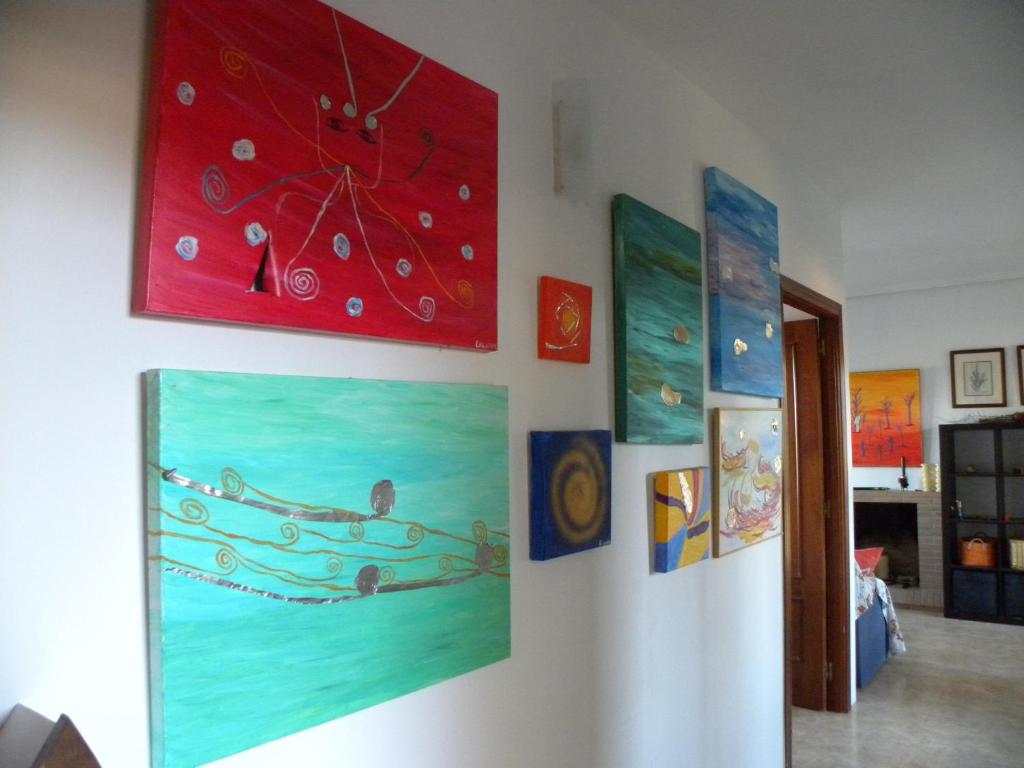 a room with paintings on a wall at El Jardin de los Gatos Apartament in Cáceres