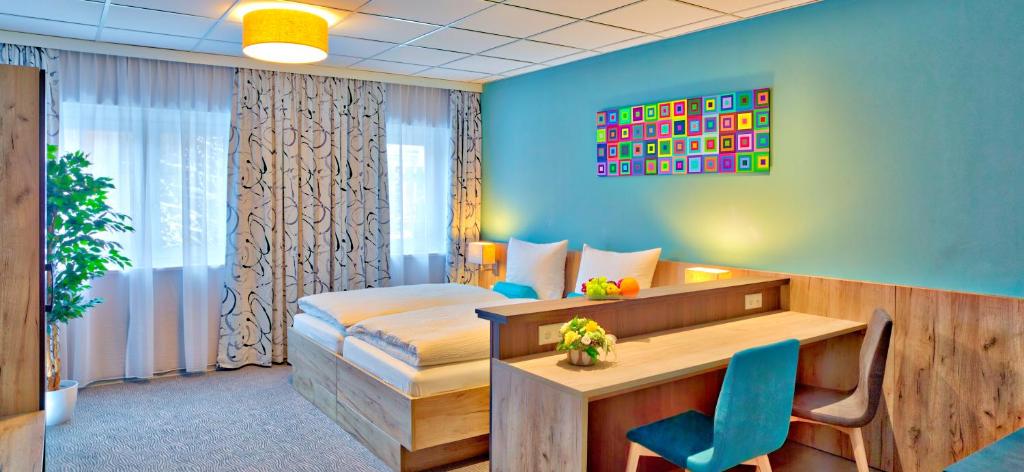 um quarto de hotel com uma cama, uma secretária e uma cadeira em das MAX Appartementhaus em Bad Wörishofen