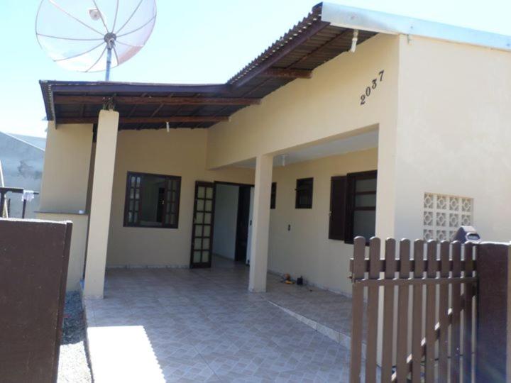 ein Haus mit einem Zaun davor in der Unterkunft Casa na Praia - Uma quadra do mar in Itapoa