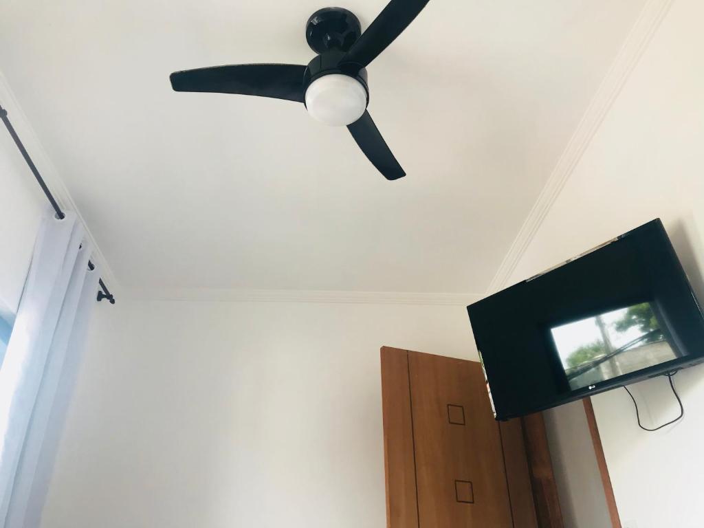 a ceiling fan and a television in a room at Apartamentos da praia in Arraial do Cabo