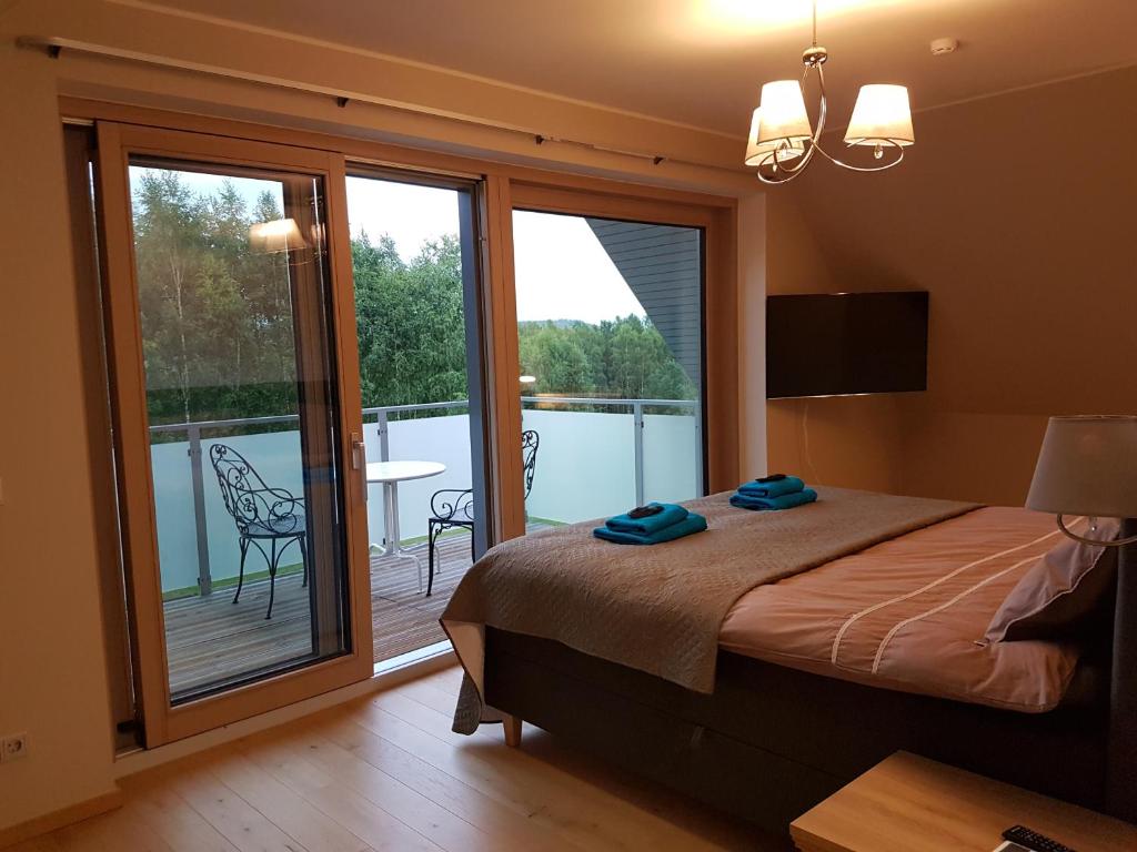 sypialnia z łóżkiem oraz balkon ze stołem w obiekcie William Willa w mieście Otepää