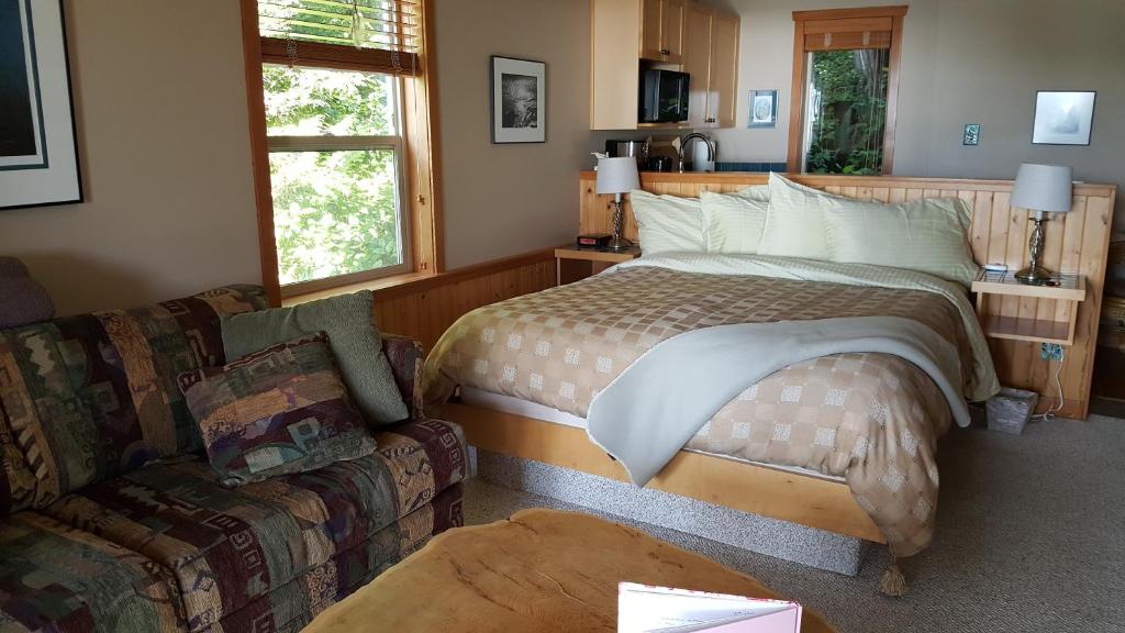 una camera da letto con un letto e un divano di Reef Point Oceanfront Bed and Breakfast a Ucluelet