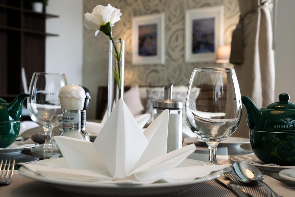 a table with a plate with a flower in a vase at Apartment Holata 401 in Hradec Králové