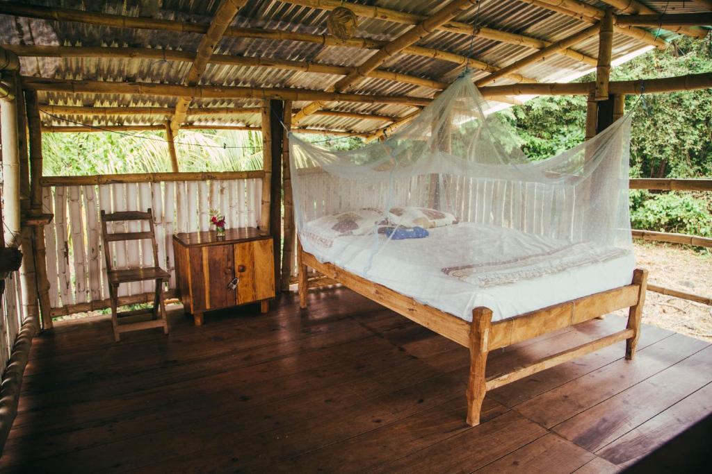1 dormitorio con 1 cama y suelo de madera en Finca La Magia, en Ometepe