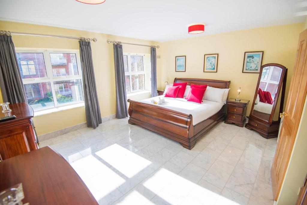 ein Schlafzimmer mit einem Bett mit roten Kissen darauf in der Unterkunft The Sir John Rodgersons Suite in Dublin